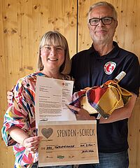 Claudia Böhler/Kinderhaus Jahnareal übergibt die Spende an Norbert Mezger vom DRK-Therapiehundedienst.